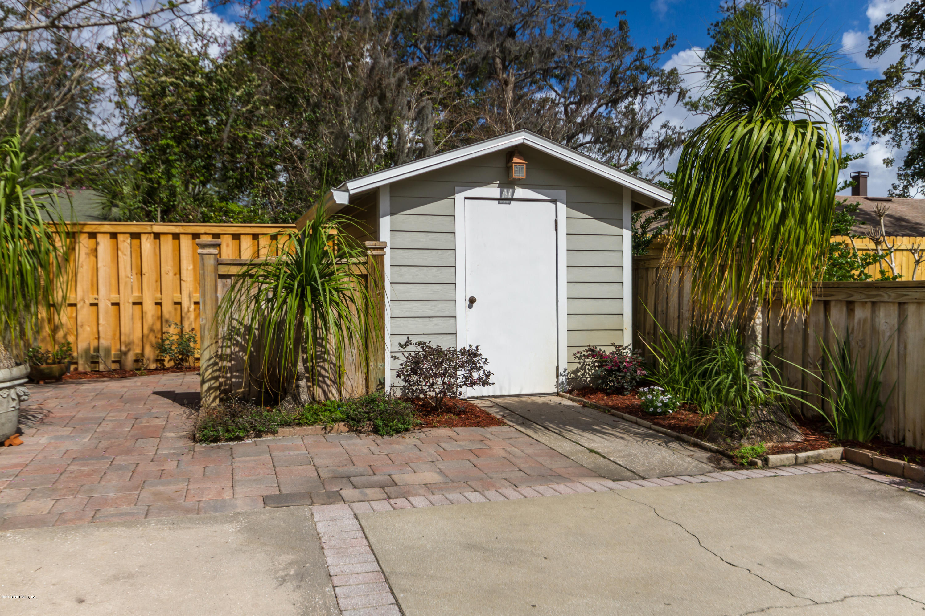 3679 Rustic Lane Jacksonville, FL 32217 - Photo 41 of 42 a small white house with a small yard and plants
