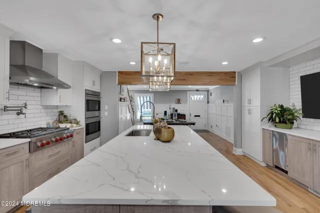 a kitchen with stainless steel appliances kitchen island granite countertop a stove and a refrigerator