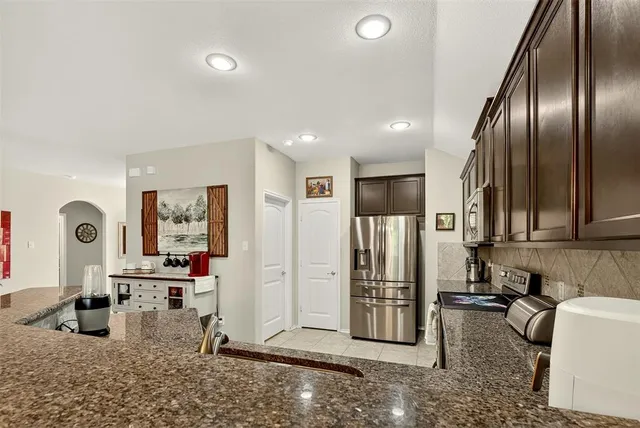 a kitchen with stainless steel appliances granite countertop a refrigerator and a sink