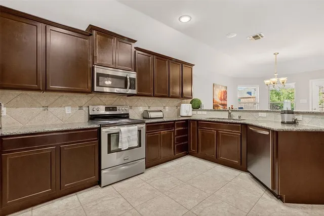 a kitchen with granite countertop cabinets stainless steel appliances and a sink