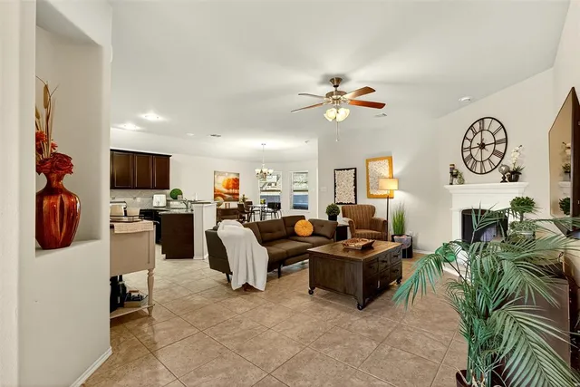 a living room with furniture a flat screen tv and kitchen view