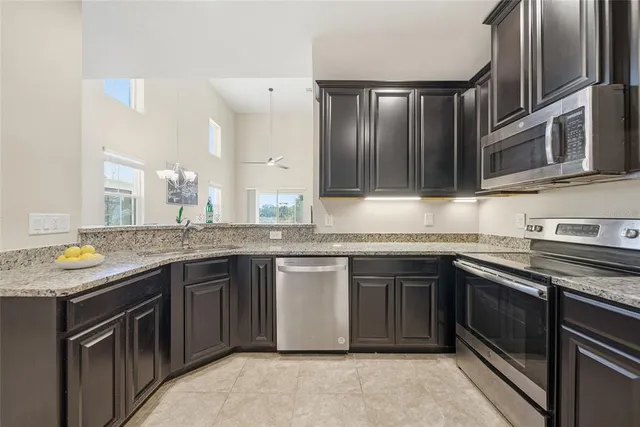 a kitchen with stainless steel appliances granite countertop a stove sink and cabinets