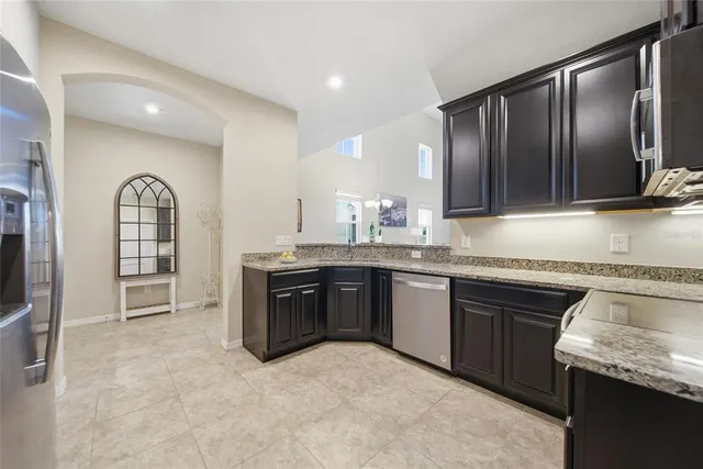 a kitchen with stainless steel appliances granite countertop a stove a sink and a microwave