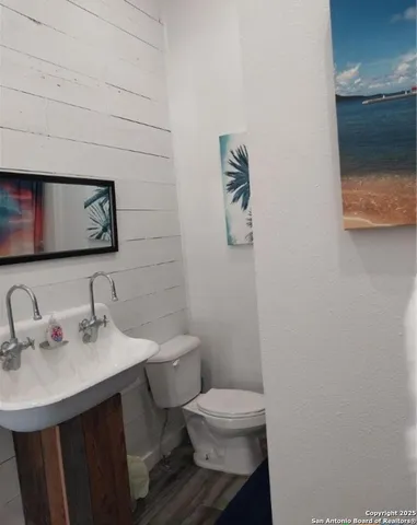 a bathroom with a sink mirror and toilet