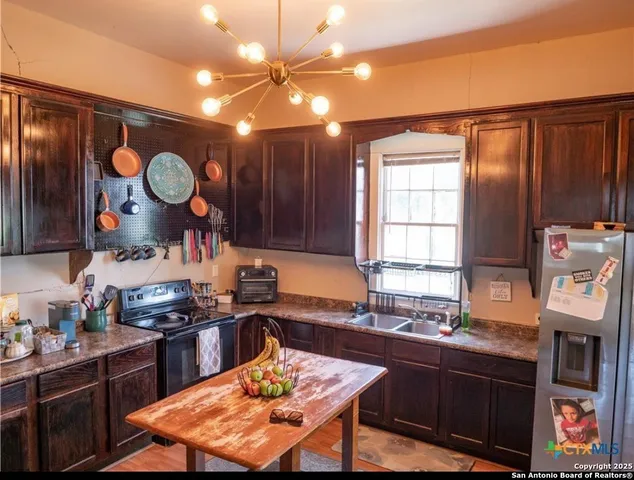 a kitchen with granite countertop a stove a sink dishwasher and cabinets with wooden floor