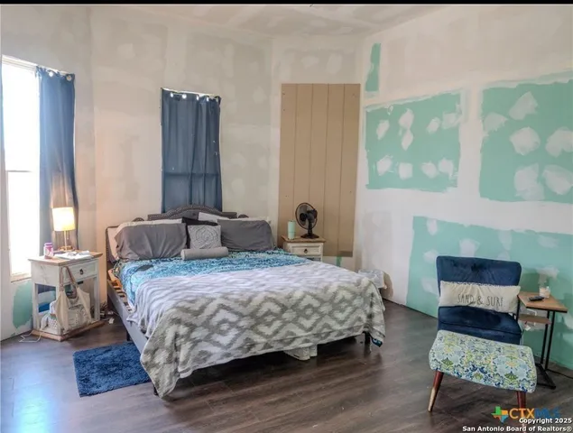 a bedroom with a bed a mirror and a potted plant