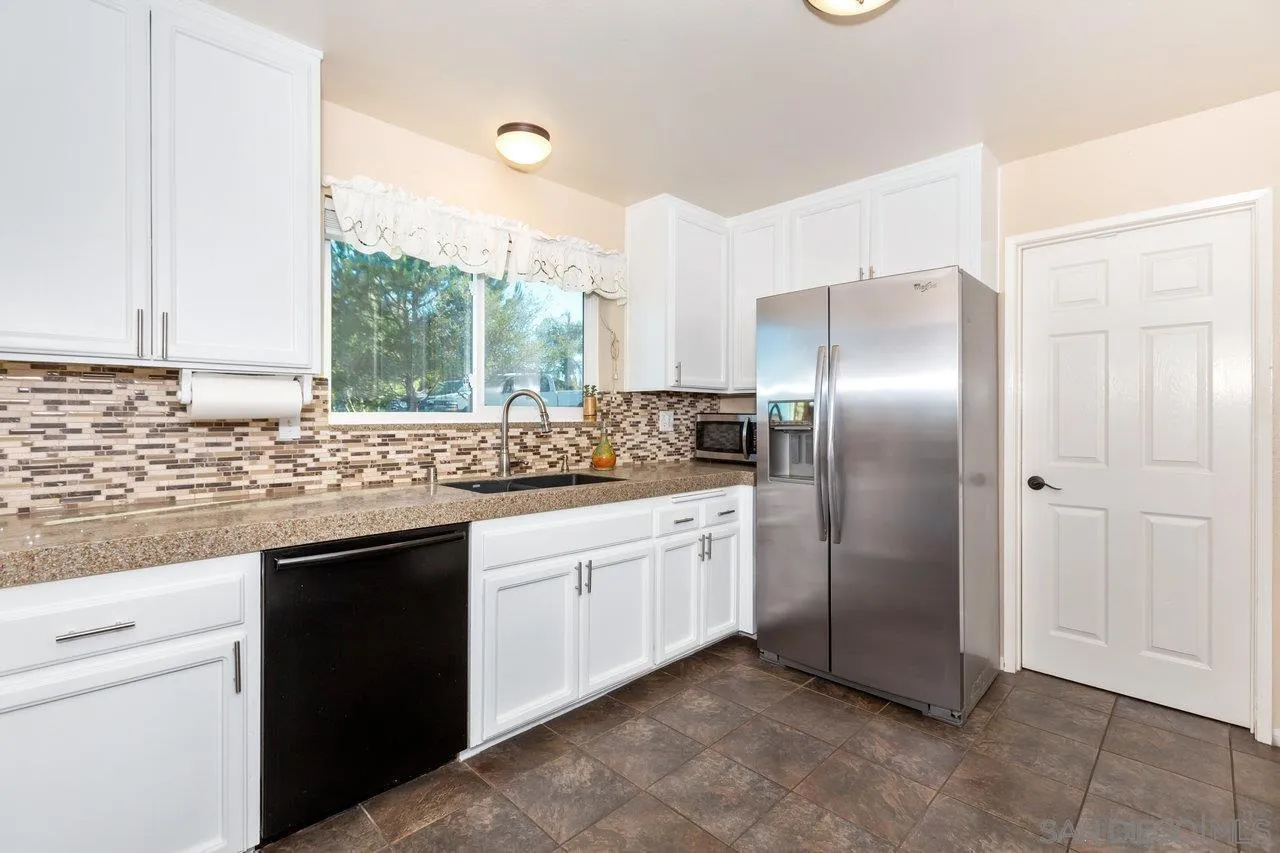 28423 Wimbleton Lane Escondido, CA 92026 - Photo 9 of 25 a kitchen with stainless steel appliances granite countertop a sink and a refrigerator