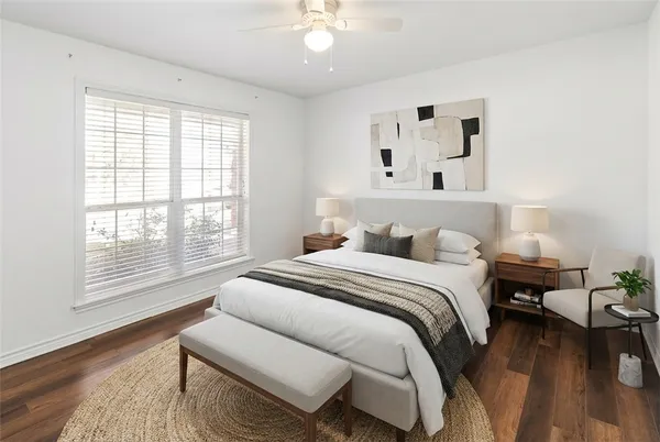 a spacious bedroom with a bed and wooden floor