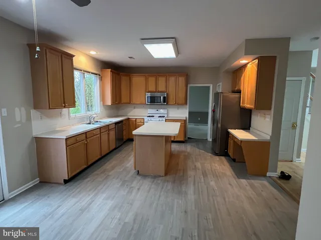 a large kitchen with a wooden floor and a large window