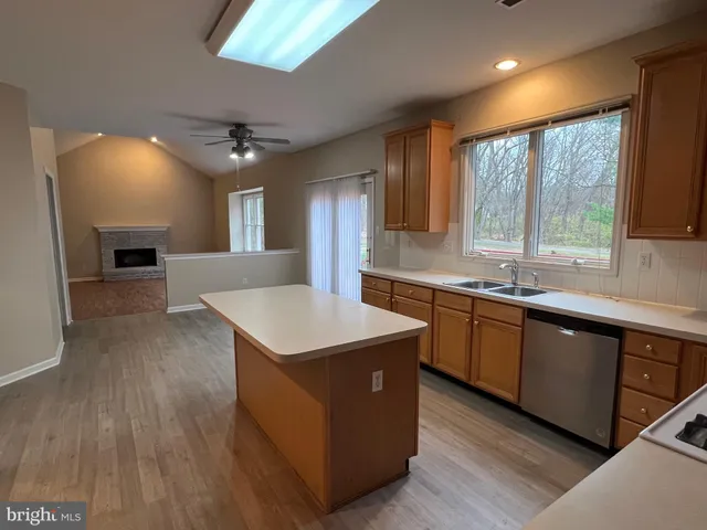 a kitchen with stainless steel appliances granite countertop a sink a stove and a wooden floors