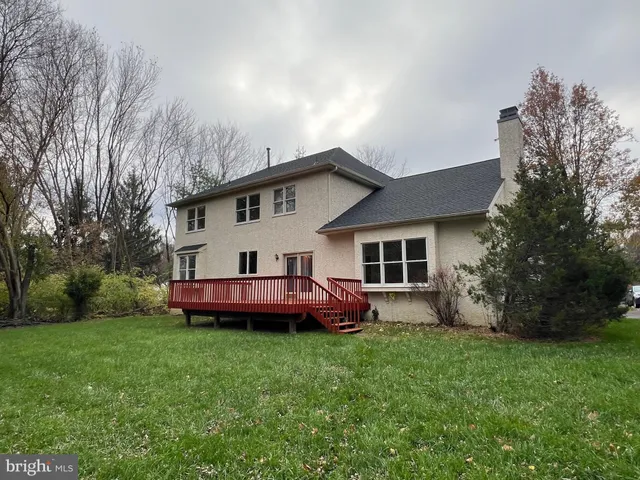 a front view of house with a garden and trees