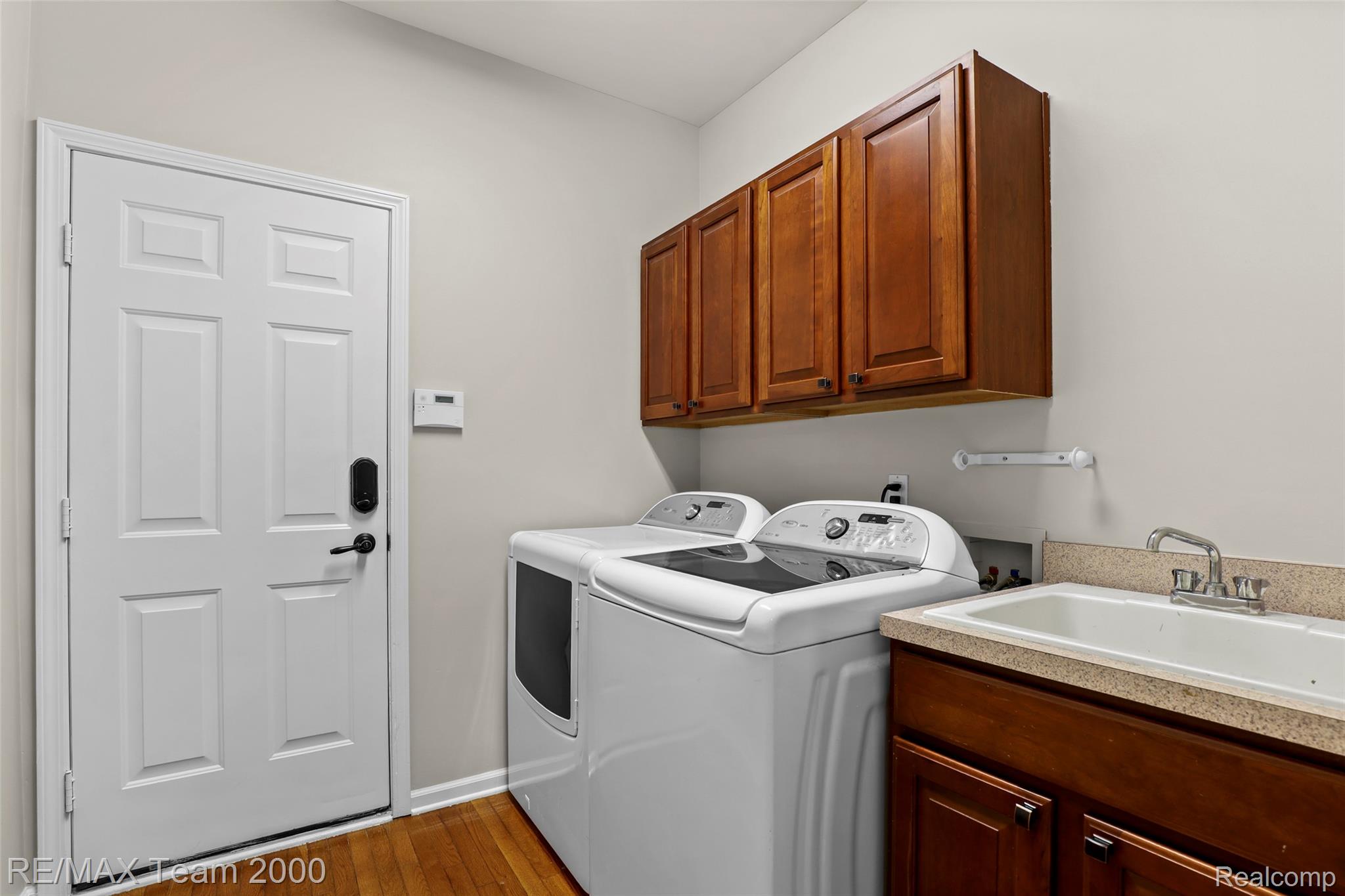 1248 Lasalle Road Canton, MI 48187 - Photo 38 of 67 Functional laundry space featuring wood-finish flooring, a utility sink with a laminate countertop, and cabinetry for storage