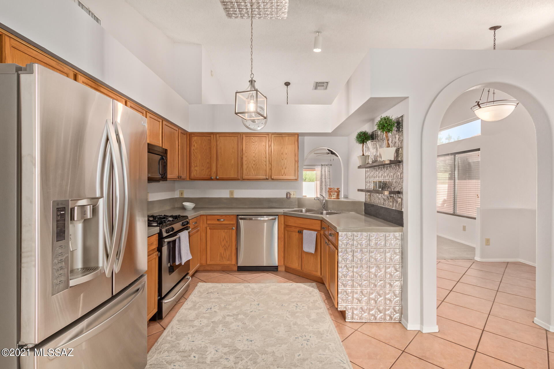 3034 West Sky Ranch Trail Tucson, AZ 85742 - Photo 11 of 27 a kitchen with stainless steel appliances granite countertop a refrigerator a sink and a stove