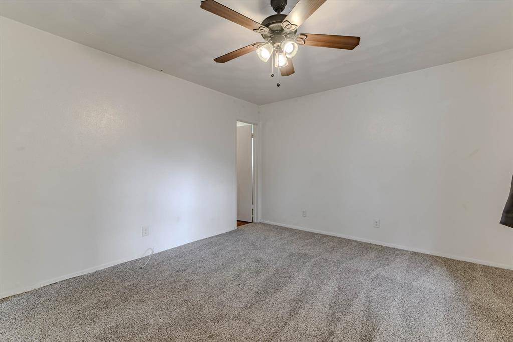 3213 Thames Street Irving, TX 75062 - Photo 14 of 25 an empty room with a fan and a chandelier fan