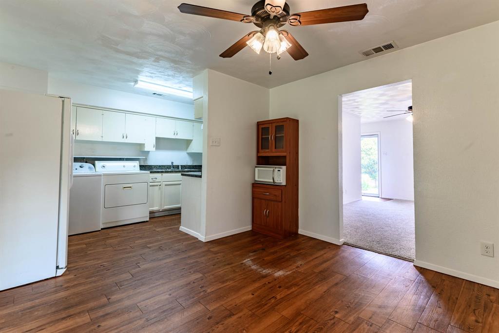 3213 Thames Street Irving, TX 75062 - Photo 7 of 25 a view of a kitchen with a fridge wooden floor and a ceiling fan