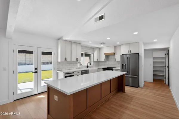 a kitchen with a stove a refrigerator and a microwave oven with wooden floor