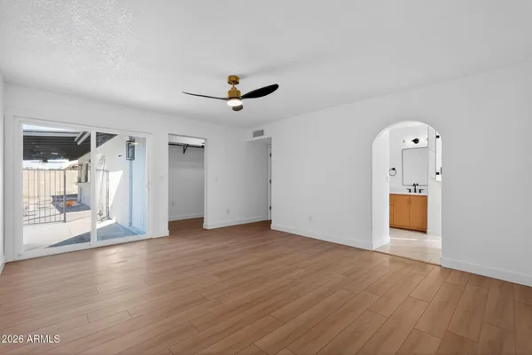a view of a livingroom with wooden floor and a ceiling fan