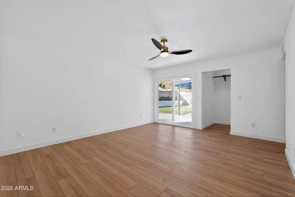a view of an empty room with wooden floor and a window