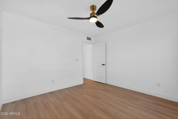 a view of a room with wooden floor a ceiling fan