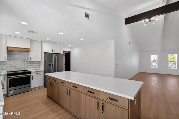 a large kitchen with a stove and a refrigerator
