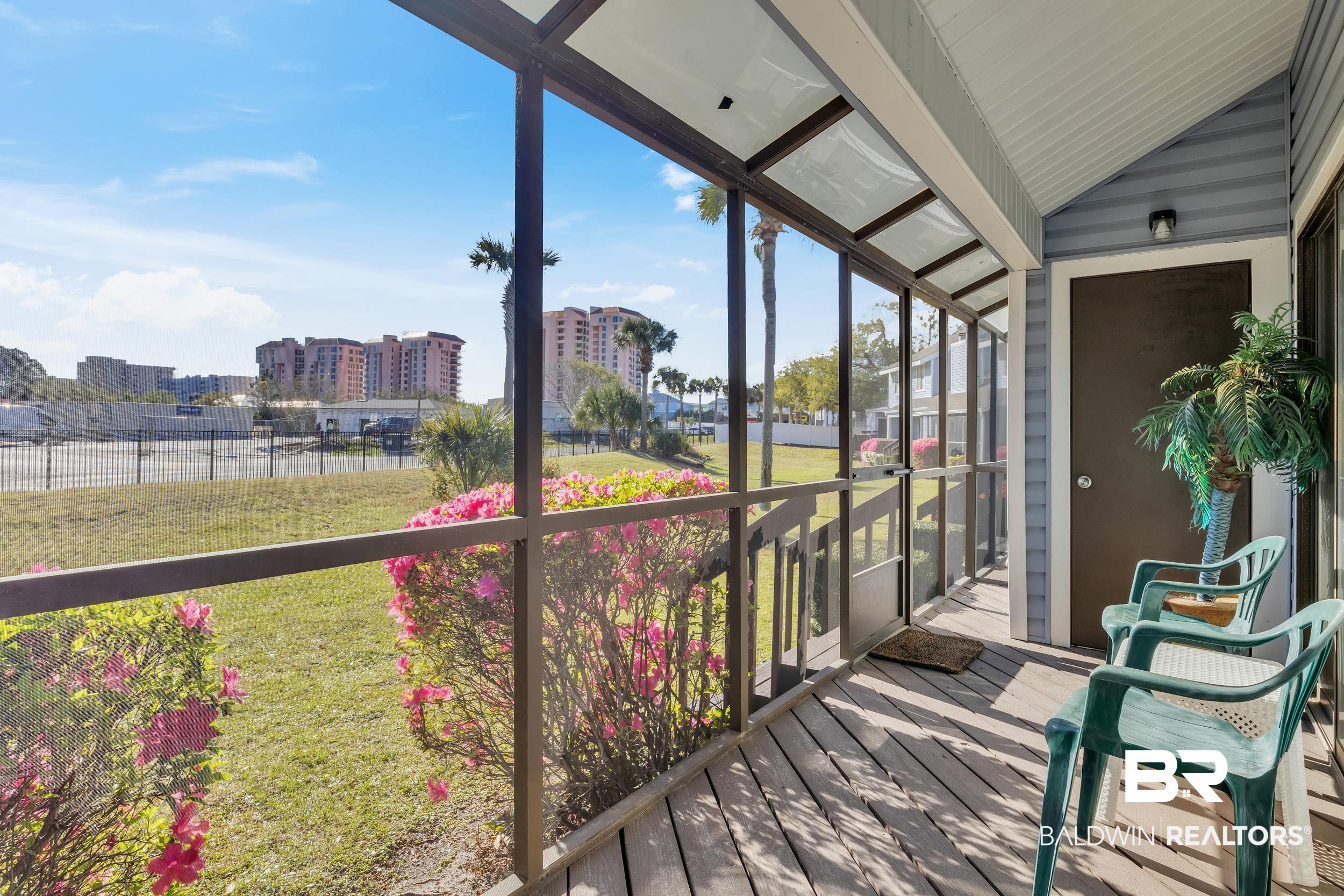3256 Loop Road, Unit 2 Orange Beach, AL 36561 - Photo 18 of 25 Screened porch featuring wood-finish flooring and a light blue paneled exterior wall