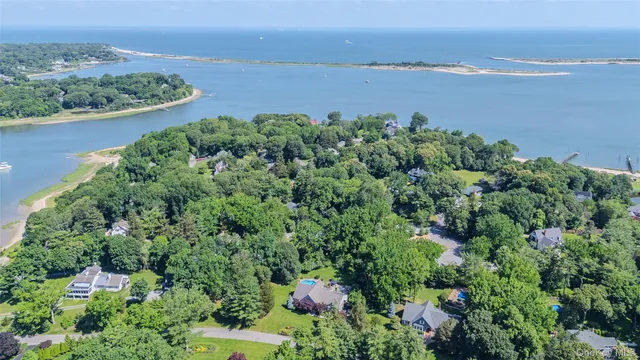 an aerial view of a houses with a yard and lake view