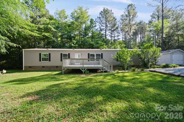 a view of a house with a backyard and a patio