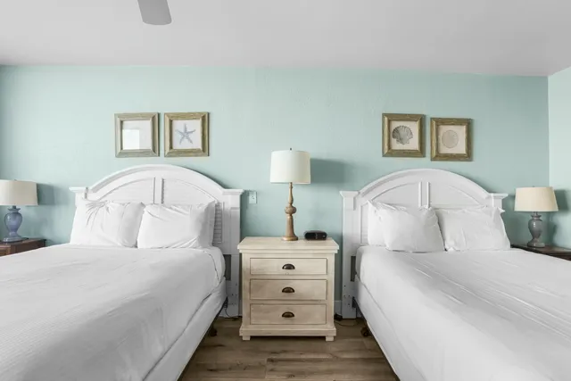 a bedroom with a bed and a lamp on dresser