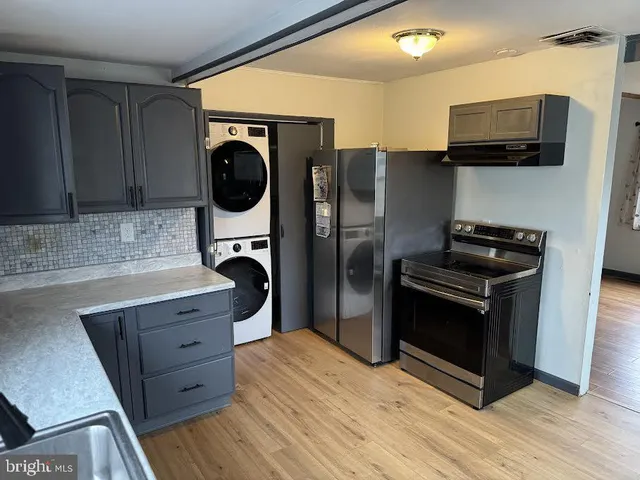 a kitchen with stainless steel appliances granite countertop a refrigerator a stove a sink and a microwave