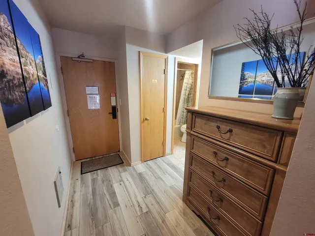 a view of a hallway with wooden floor and staircase