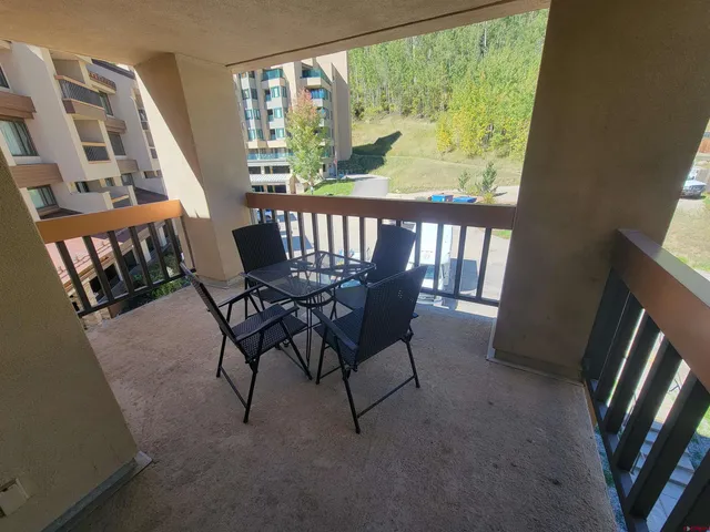 a view of a balcony with furniture and a floor to ceiling window