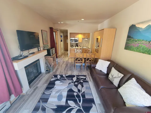 a living room with furniture a flat screen tv and a fireplace
