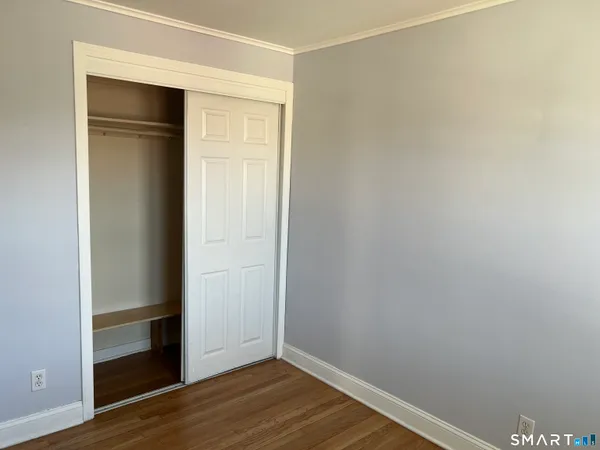 a view of an empty room with wooden floor