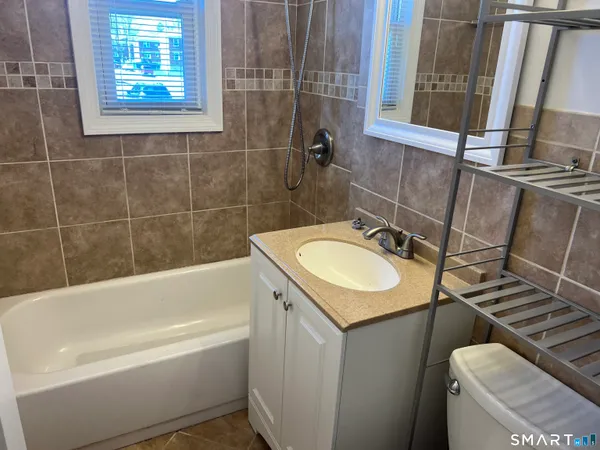 a bathroom with a granite countertop sink toilet and bathtub