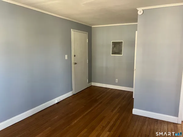 a view of an empty room with wooden floor