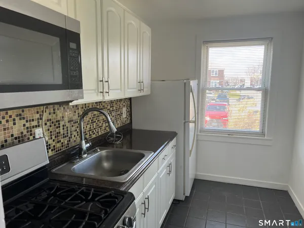 a kitchen with a sink stove and cabinets