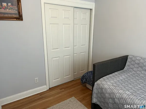 a bedroom with a bed and wooden floor