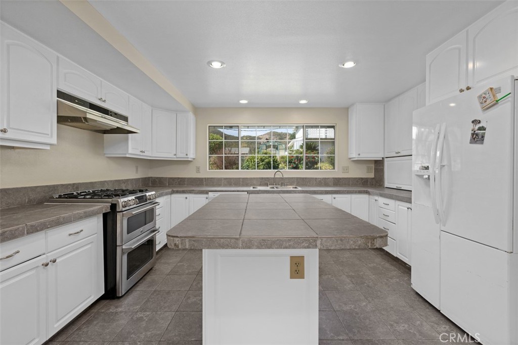 35768 Rice Canyon Road Fallbrook, CA 92028 - Photo 13 of 39 a kitchen with stainless steel appliances granite countertop a stove a sink and a refrigerator
