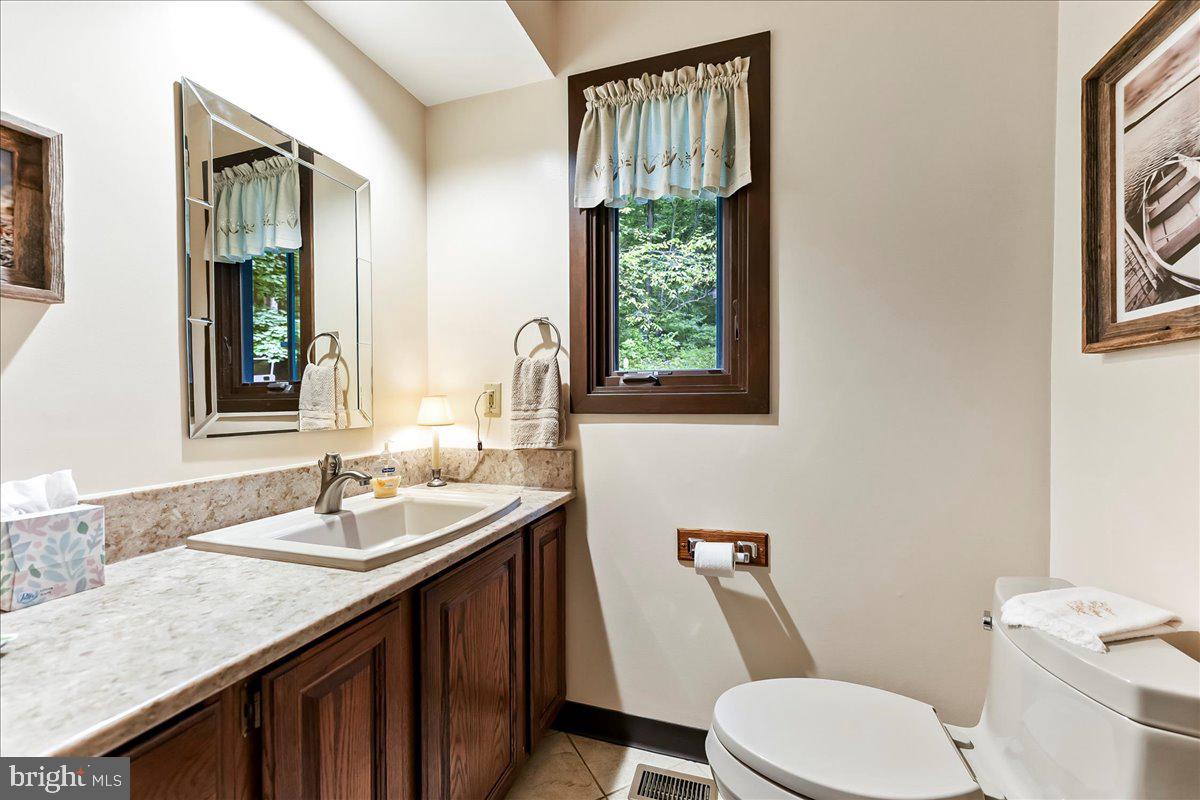 1200 Dunsinane Hill Chester Springs, PA 19425 - Photo 12 of 42 a bathroom with a granite countertop toilet sink and mirror