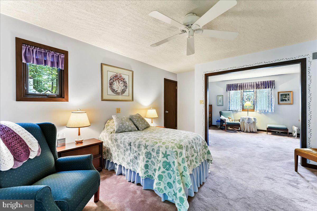 1200 Dunsinane Hill Chester Springs, PA 19425 - Photo 15 of 42 a bedroom with a bed a couch and a large window