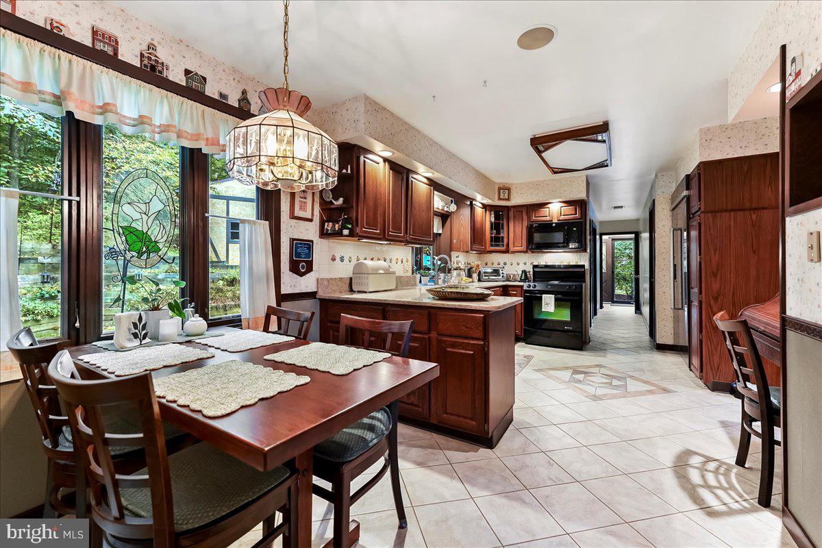 1200 Dunsinane Hill Chester Springs, PA 19425 - Photo 9 of 42 a open kitchen with stainless steel appliances granite countertop a stove a refrigerator a oven a sink a dining table and chairs with the floor