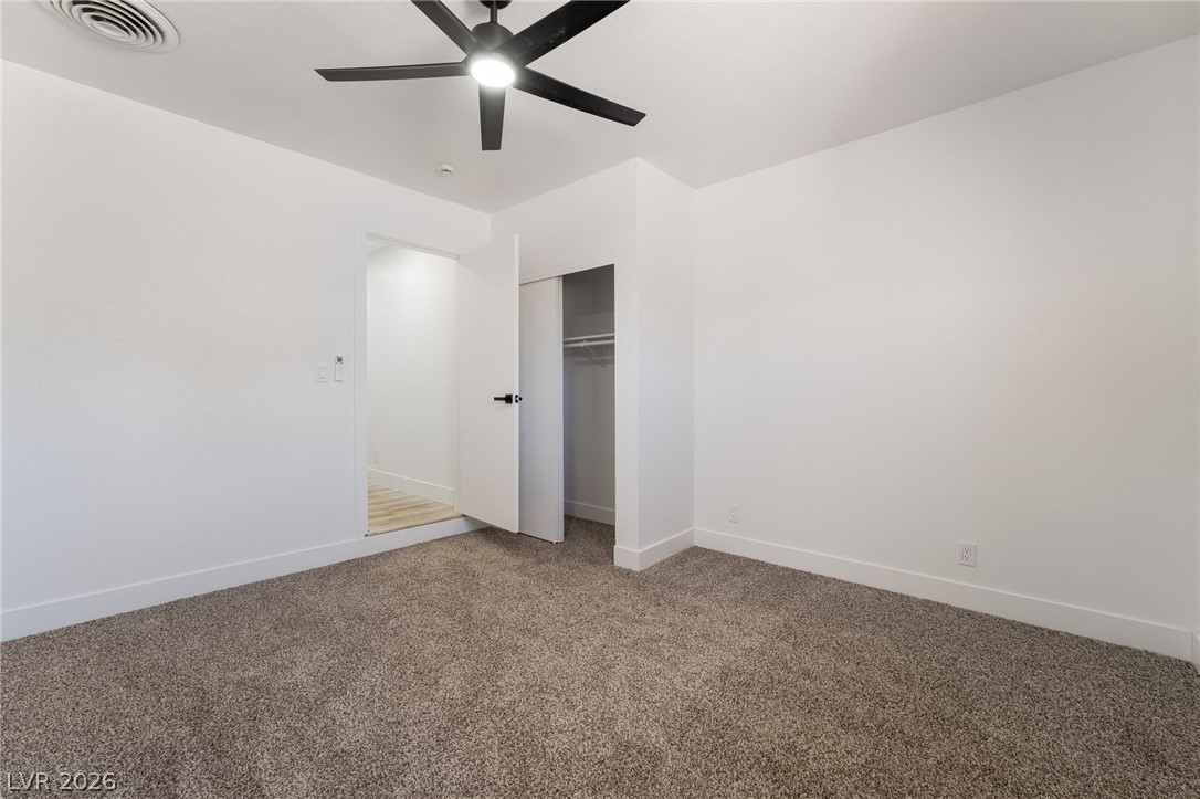 39 Lowery Street Henderson, NV 89015 - Photo 15 of 40 A comfortable bedroom with plush carpeting and a modern ceiling fan, offering a serene personal space.