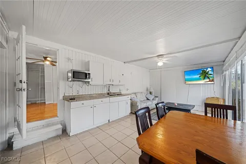 a large white kitchen with stainless steel appliances a stove a table and chairs