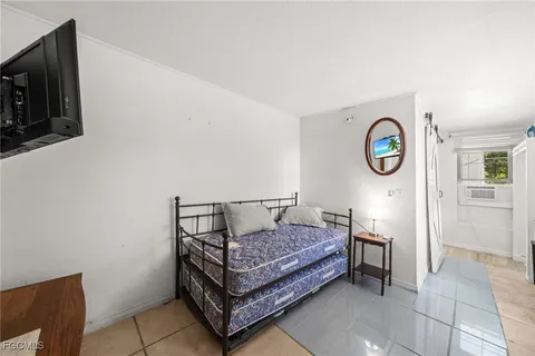 a bedroom with a bed and a tv on the wall