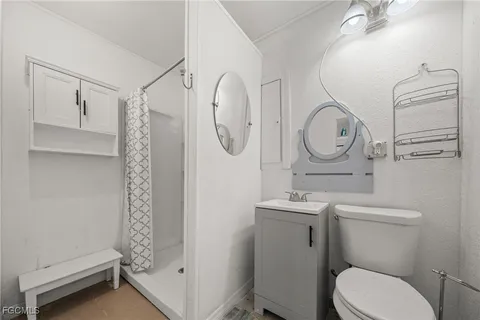 a bathroom with a toilet sink vanity and mirror