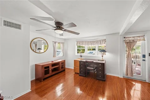 a living room with couch and a clock on the wall