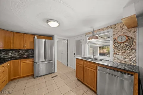 a kitchen with granite countertop a refrigerator and a stove top oven