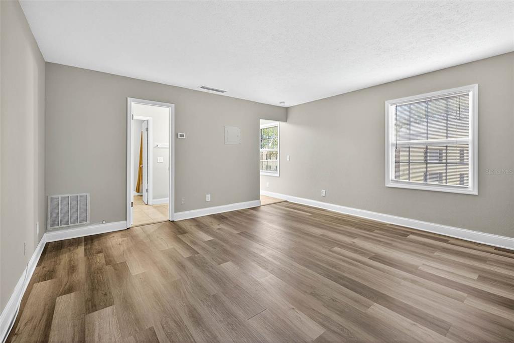 13824 Orange Sunset Drive, Unit 202 Tampa, FL 33618 - Photo 3 of 20 a view of an empty room with wooden floor and a window