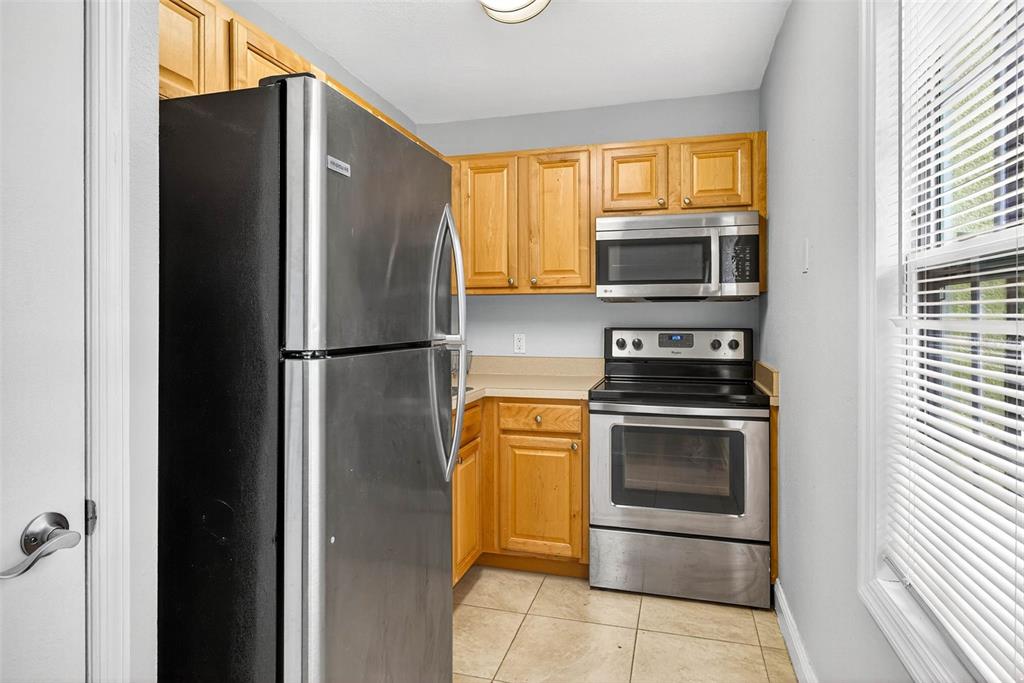 13824 Orange Sunset Drive, Unit 202 Tampa, FL 33618 - Photo 4 of 20 a kitchen with stainless steel appliances granite countertop a refrigerator and a sink