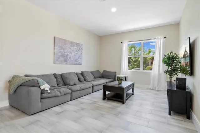 a living room with furniture and a wooden floor
